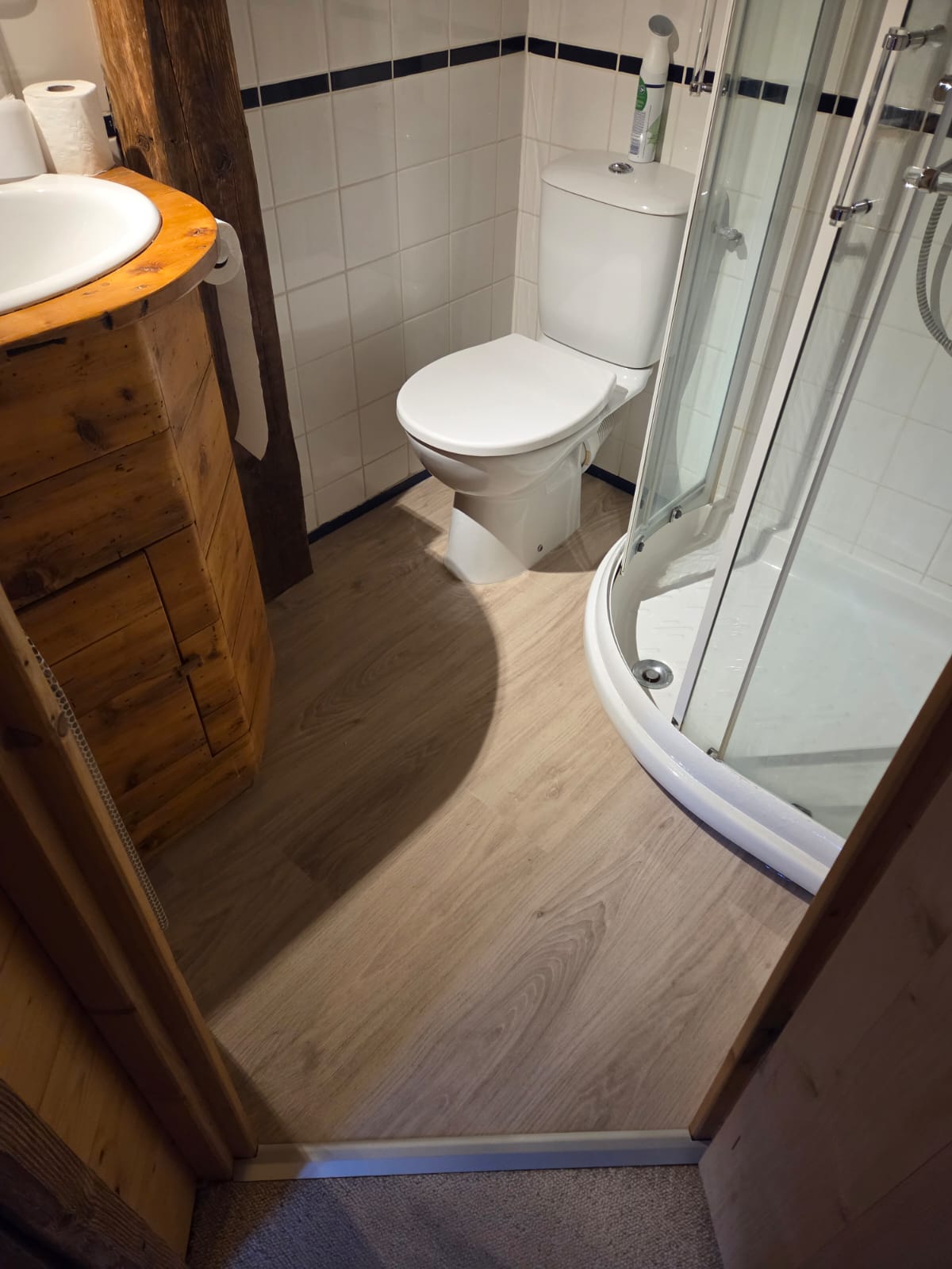 Salle de bain avec sol en PVC imitation bois et douche à l'italienne
