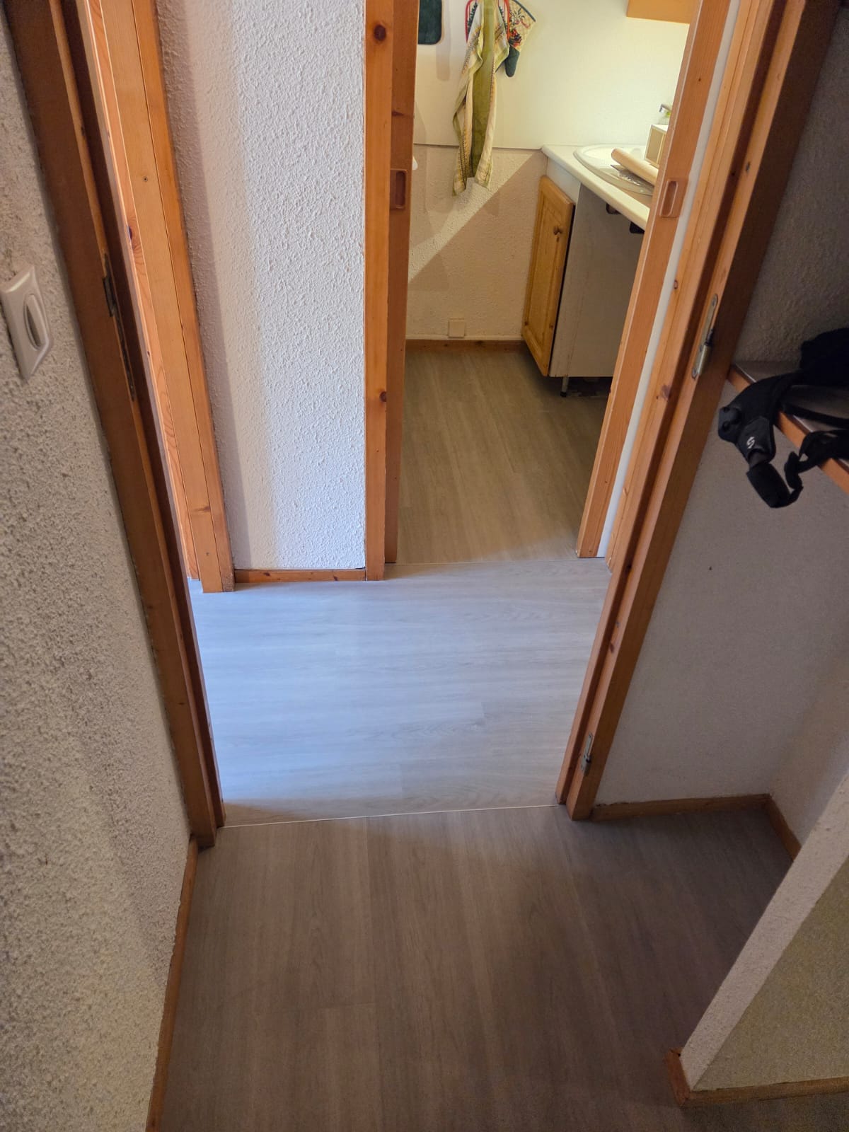 Couloir avec sol en PVC blanc cassé et parois peintes en blanc cassé
