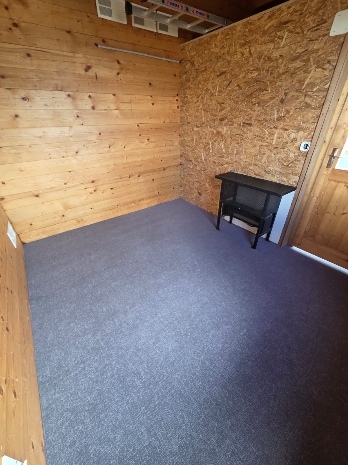 Chambre en cours de finition avec sol souple PVC gris et murs en bois clair